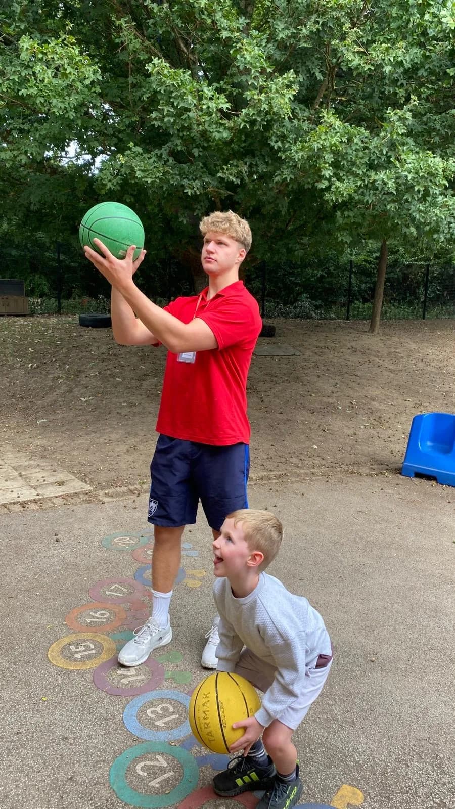A child and activity leader playing basketball
